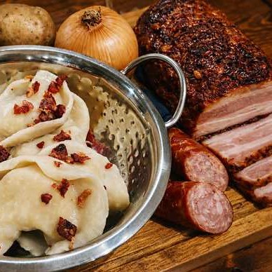 Handmade pierogi with crispy bacon, potatoes and onions